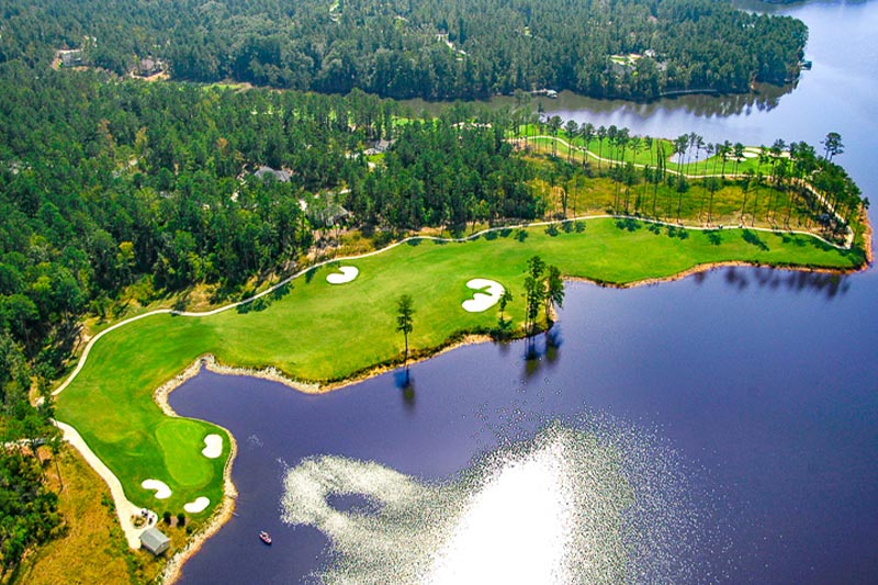 Aerial view of a golf course at Savannah Lakes Village along the shoreline of Lake Mont.