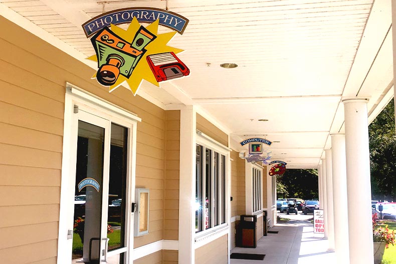 Overhead signs for photography, computer, and art studios in Sun City Hilton Head's amenity complex