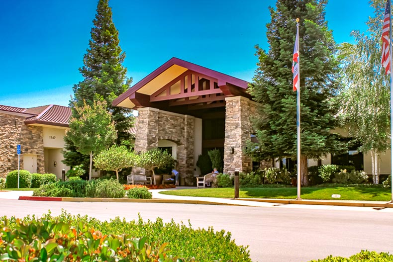 Exterior photo of a clubhouse in Sun City Lincoln Hills with a driveway curving in front