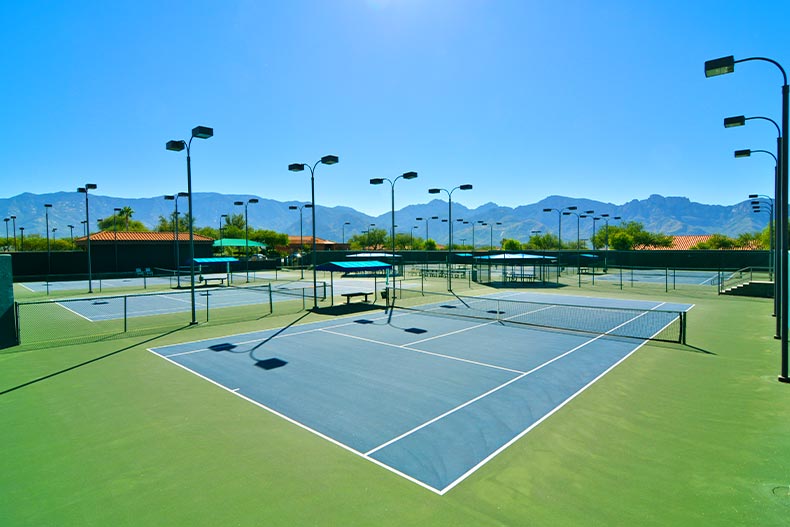 Lighted tennis courts in Sun City Oro Valley with a mountain range in the background, located in Oro Valley, Arizona
