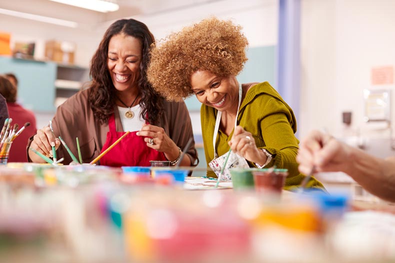 Two mature women attending art class in a community center together