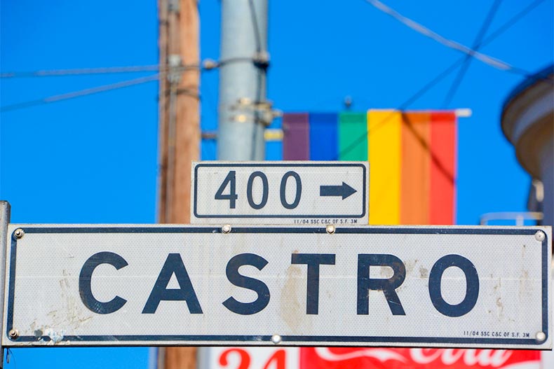 Close up of Castro street sign with rainbow colors in the background in San Francisco