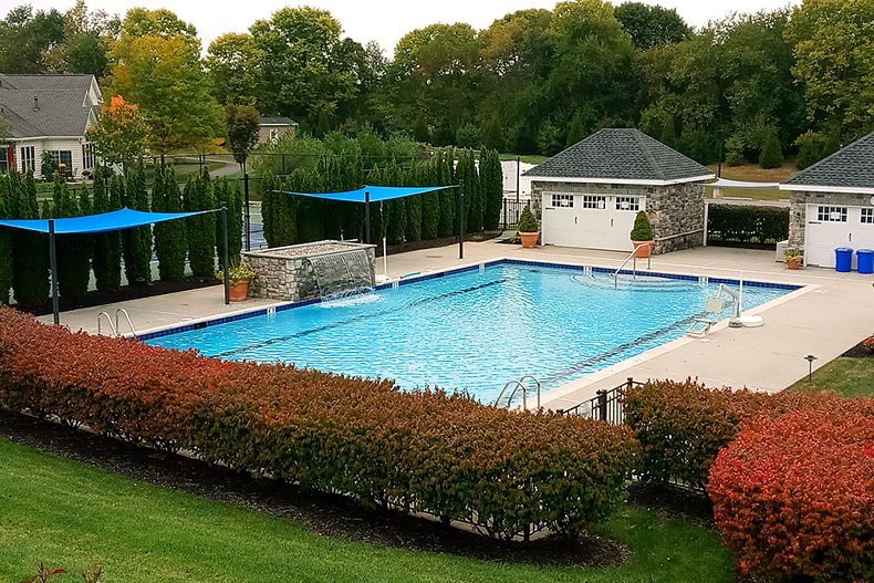 View of a pool, patio, and pool houses located in Traditions of America at Silver Spring in Mechanicsburg, Pennsylvania