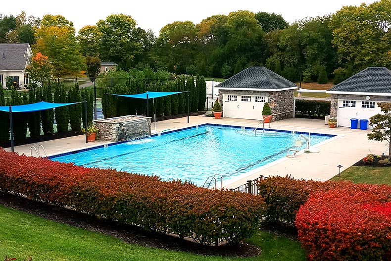 View of a pool and storage units surrounded by greenery changing from green to red, located in Traditions of America at Silver Spring in Mechanicsburg, Pennsylvania