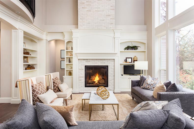 A living room with hardwood floors and a fireplace in a new luxury home