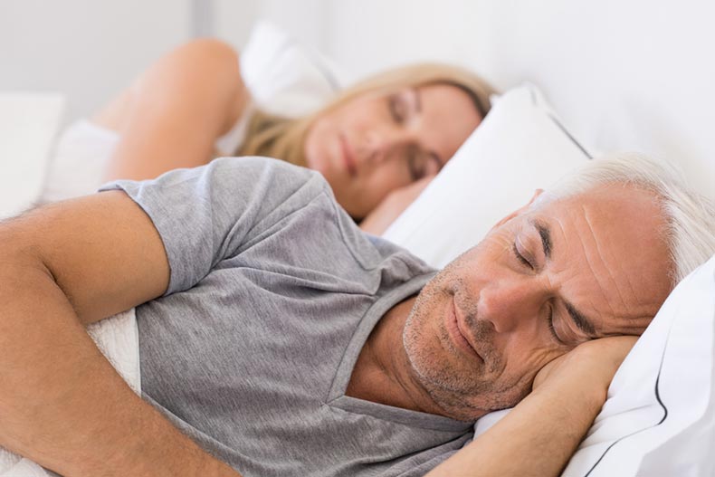 A senior man and woman sleeping peacefully