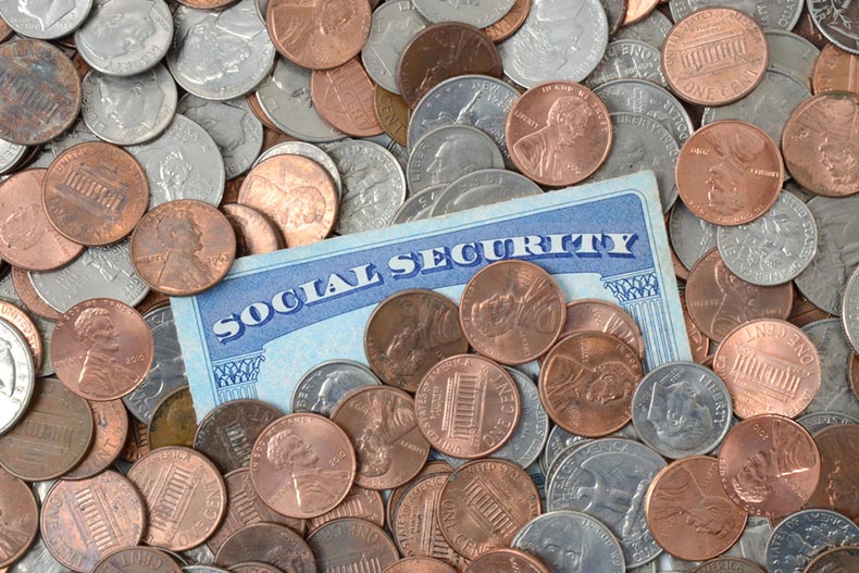 A Social Security card laying in a pile of coins