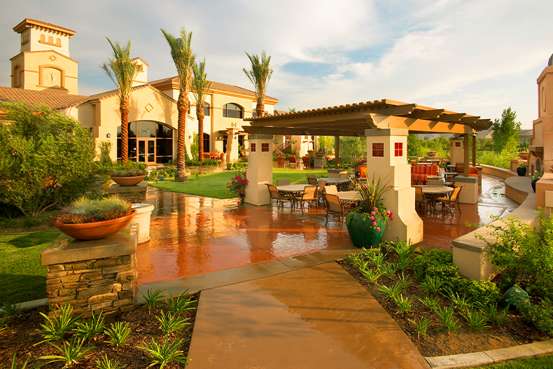 A shaded patio with greenery outside of a clubhouse in Solera Diamond Valley, located in Hemet, California after a rain shower