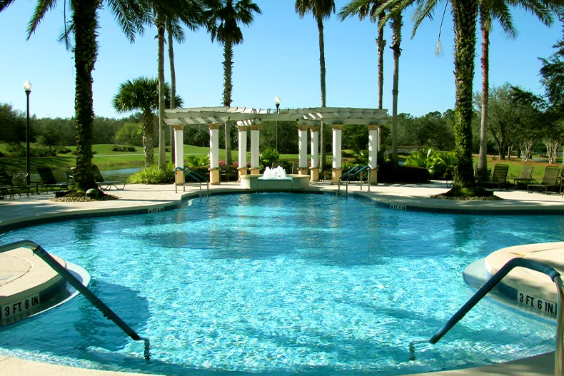 A resort-style swimming pool leading to a covered fountain, located in the Solivita community of Kissimmee, Florida