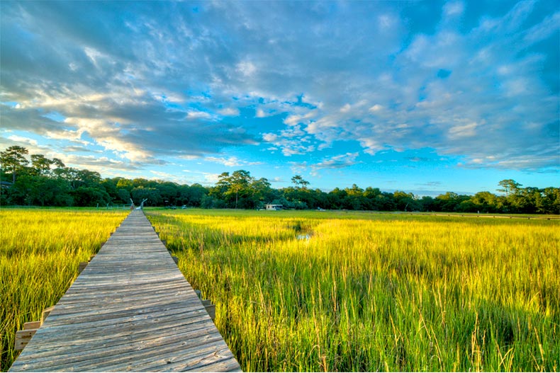 Blue sky and scattered clouds over a marshland and dock in South Carolina