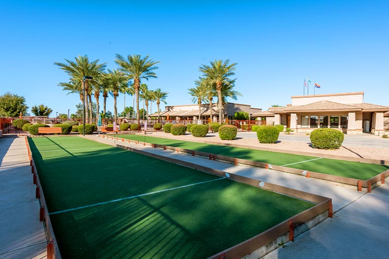 Two bocce ball courts in front of palm trees and a club house in Springfield, Chandler, Arizona
