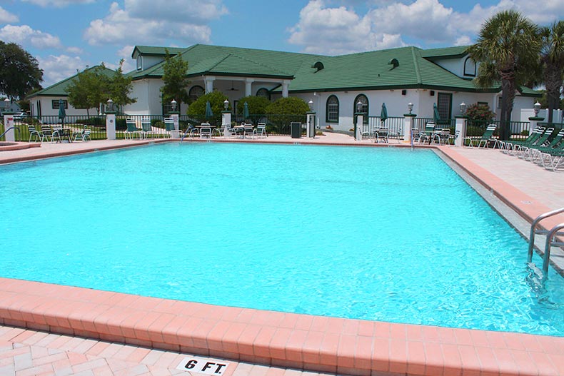 Exterior photo of the clubhouse at the Spruce Creek Preserve 55+ community in Dunnellon, Florida with a pool in the foreground