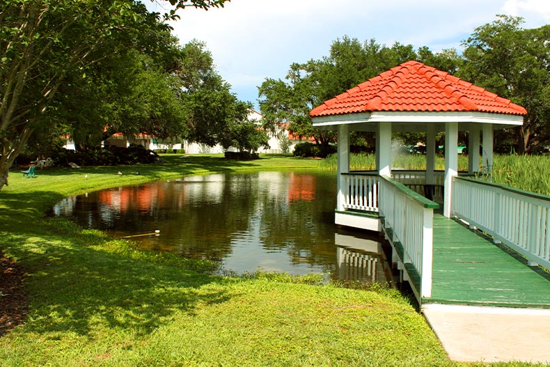 A red-roofed gazebo and pier over a small pond in Spruce Creek South, located in Summerfield, Florida