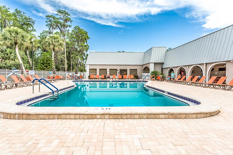 Summertree outdoor pool and patio with the clubhouse in the background.
