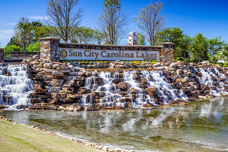 A man-made waterfall beneath the community sign for Sun City Carolina Lakes in Indian Land, South Carolina