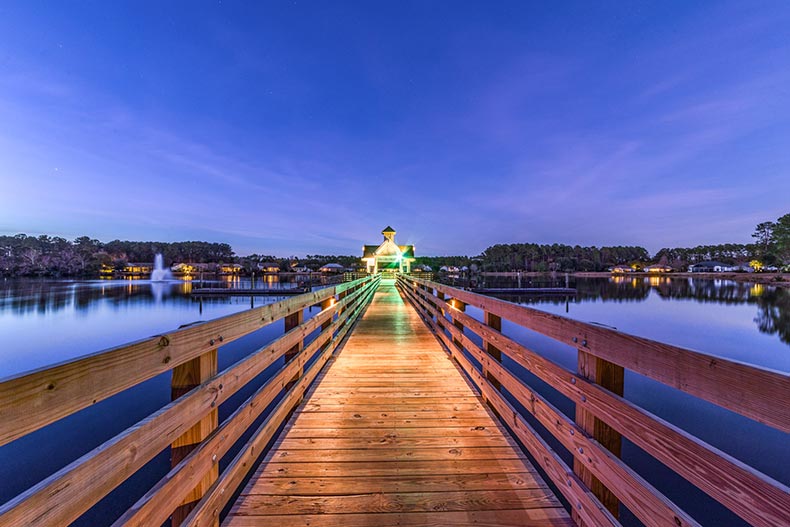 Nighttime view down a boardwalk over a pond at Sun City Hilton Head in Bluffton, South Carolina