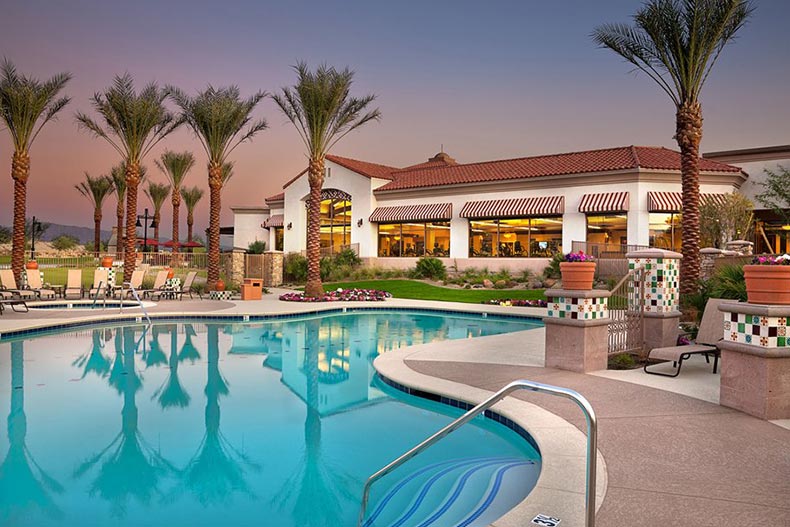 Palm trees surrounding the clubhouse and outdoor pool at Sun City Shadow Hills in Indio, California