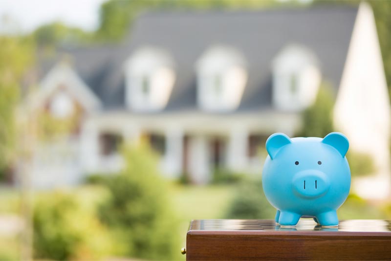 piggy bank in front of residential home for sale