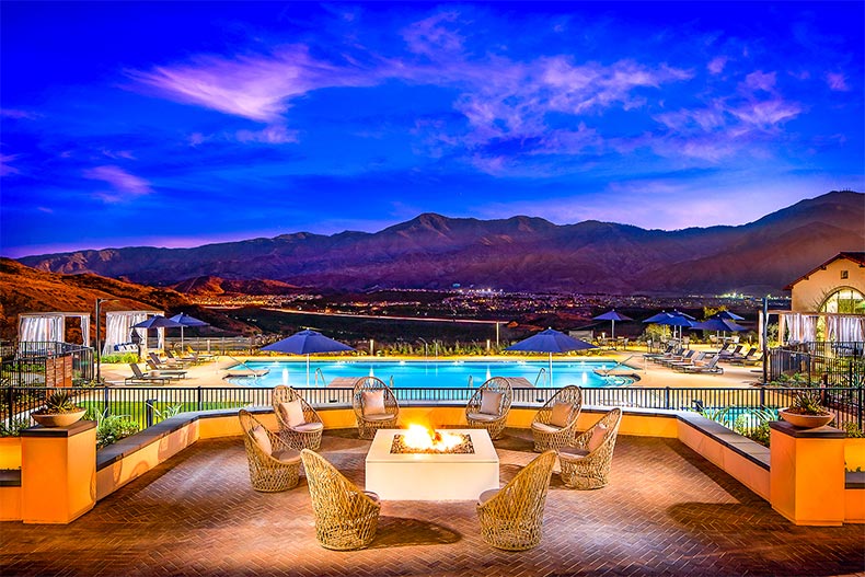 Chairs around a fire pit in front of resort-style pool with stunning mountain views in Terramor