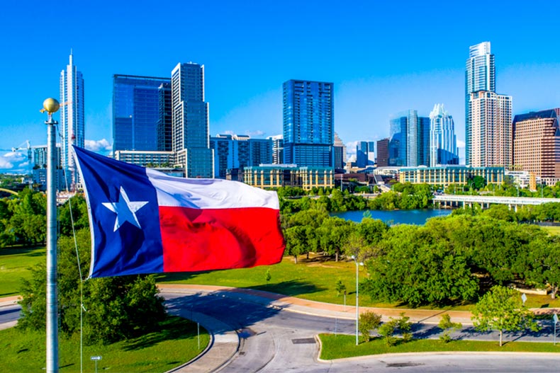 Texas flag with Austin, Texas skyline and a blue sky in the background
