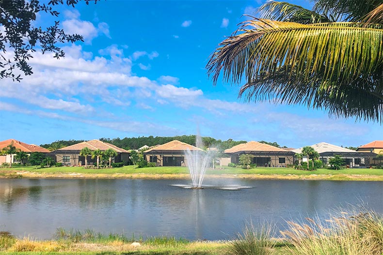 A fountain in a pond beside homes in The Plantation in Fort Myers, Florida