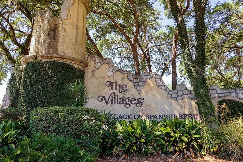 The community sign for The Villages on a stone wall