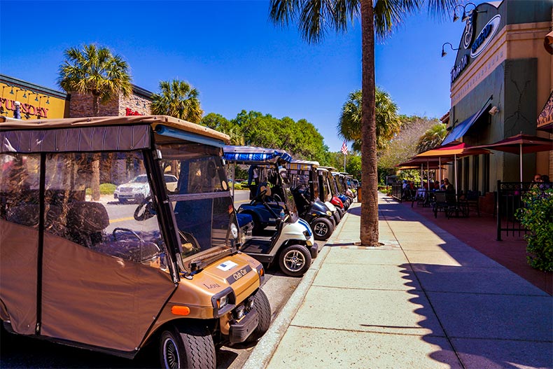 Golf cars parks outside retail shops in The Villages, Florida