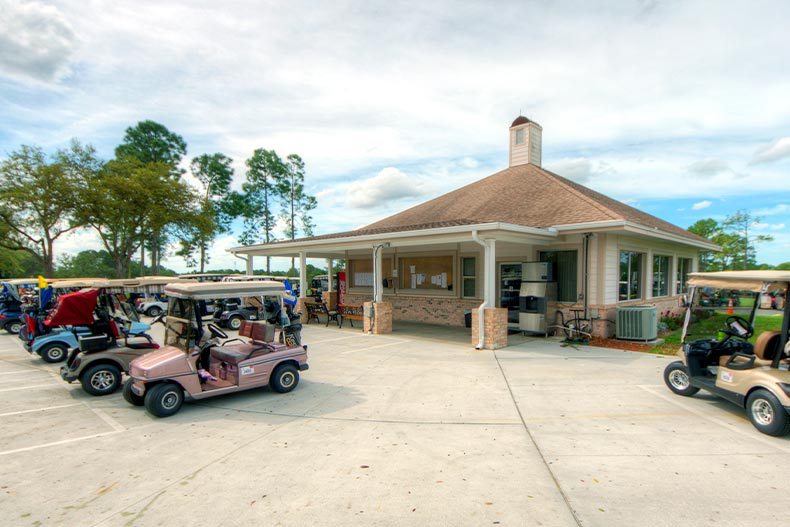 Several golf carts parked outside of a pro shop in Timber Pines of Spring Hill, FL