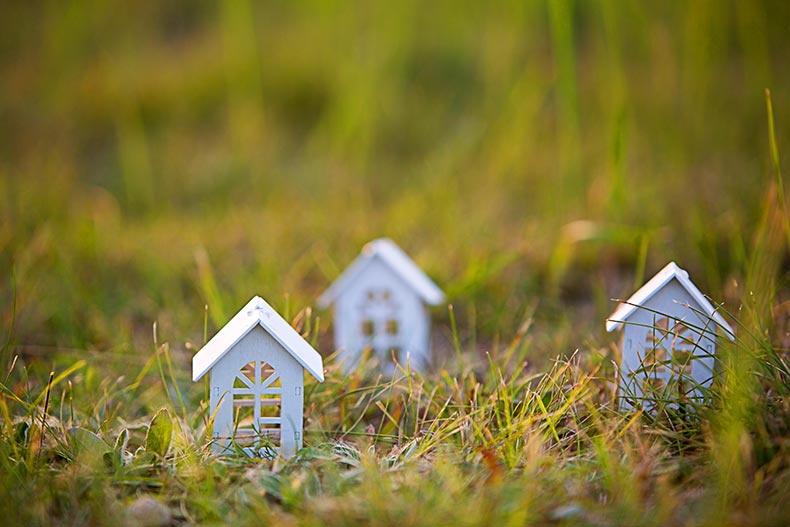 Closeup of tiny, white wooden houses on grass