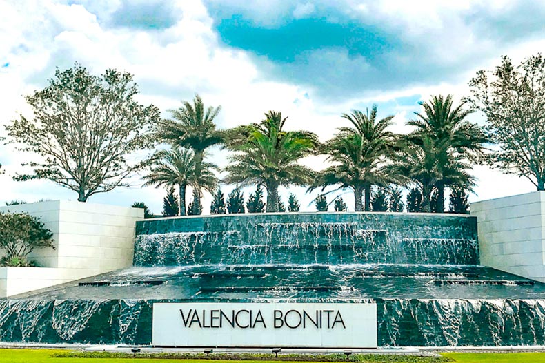 Photo of a waterfall fountain with palm trees in back and a sign that reads "Valencia Bonita" centered in the front.
