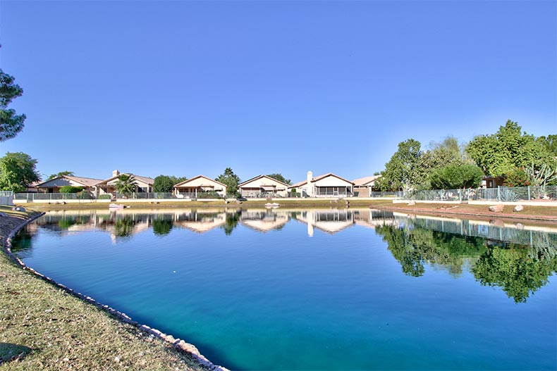 Houses and trees beside a calm pond at Ventana Lakes in Peoria, Arizona