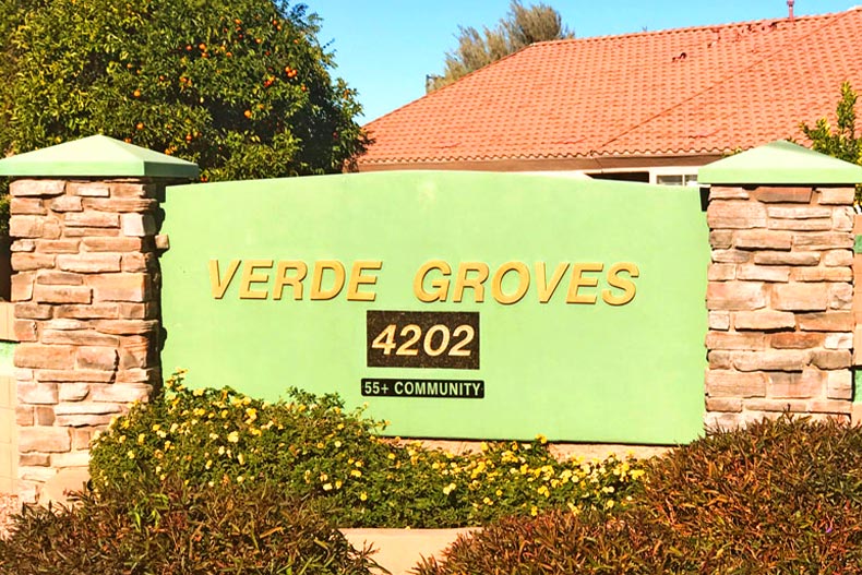 Photo of the entrance sign at Verde Groves surrounded by shrubbery in Mesa, AZ