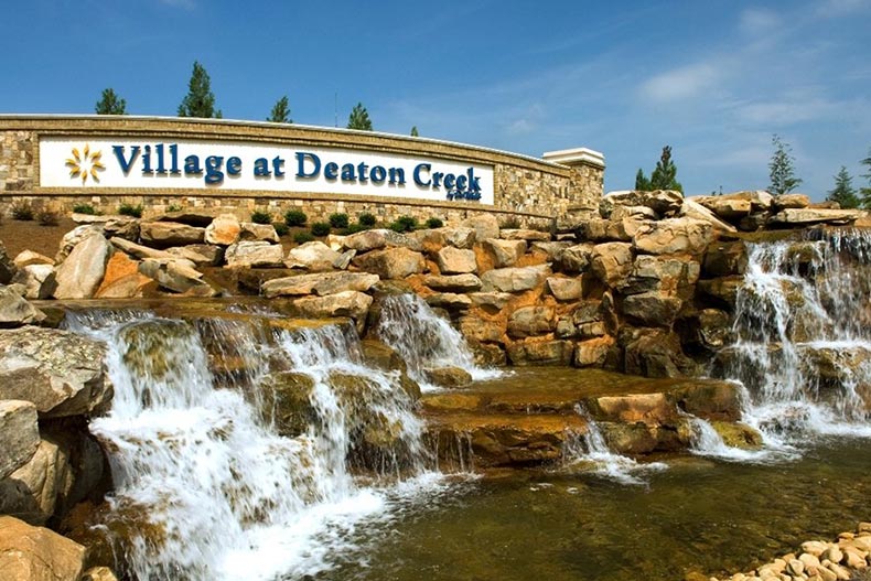 A rocky waterfall beneath the community sign for Village at Deaton Creek in Hoschton, Georgia