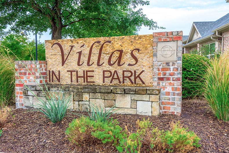 Greenery surrounding the community sign for Villas in the Park in Fairview, Texas