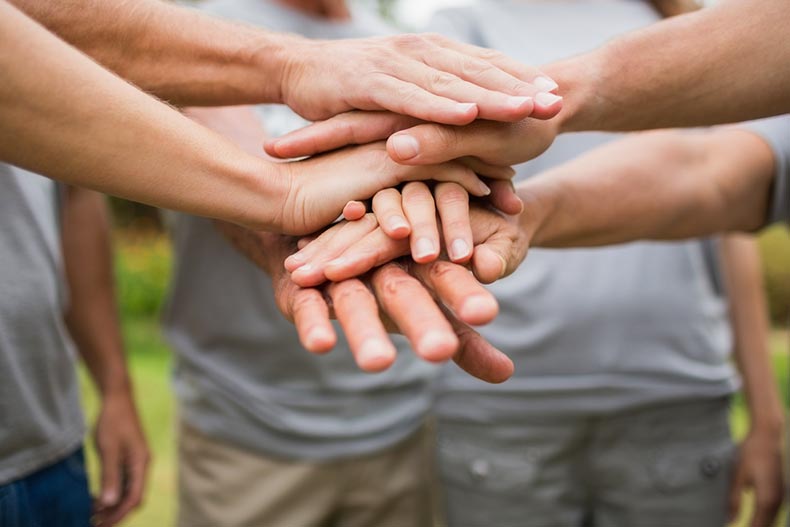 A group of volunteers putting their hands together