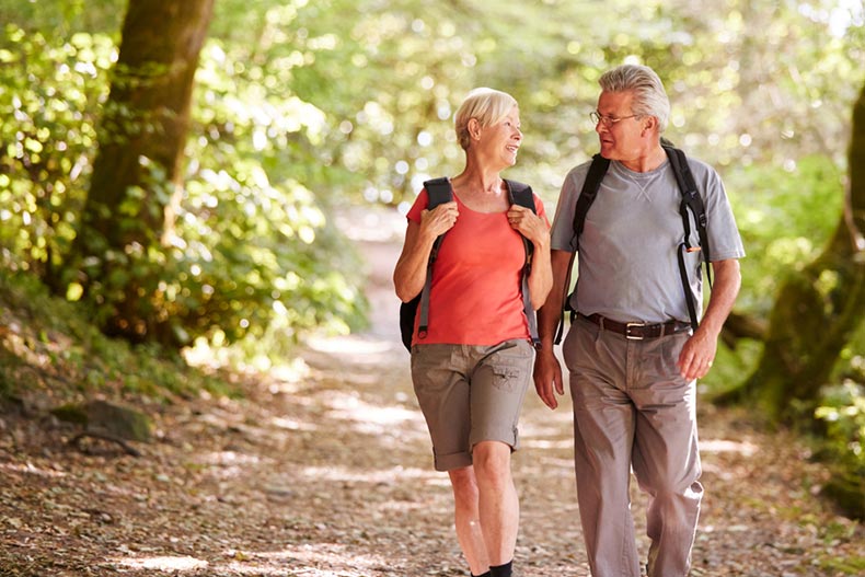 A senior couple hiking along a trail near the 55+ community they live in