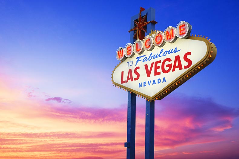 "Welcome to Fabulous Las Vegas Nevada" neon sign with a desert sunset in the background