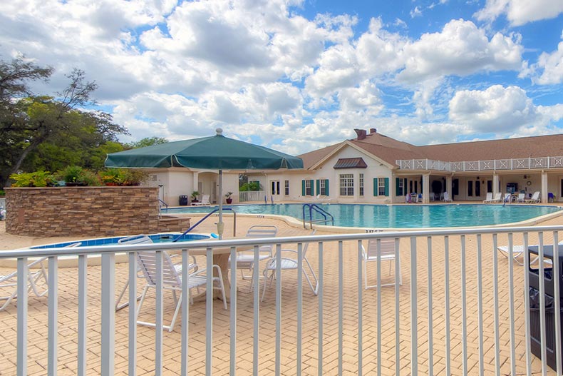 Lounge chairs beside the outdoor pool and whirlpool spa at Wellington at Seven Hills in Spring Hill, Florida