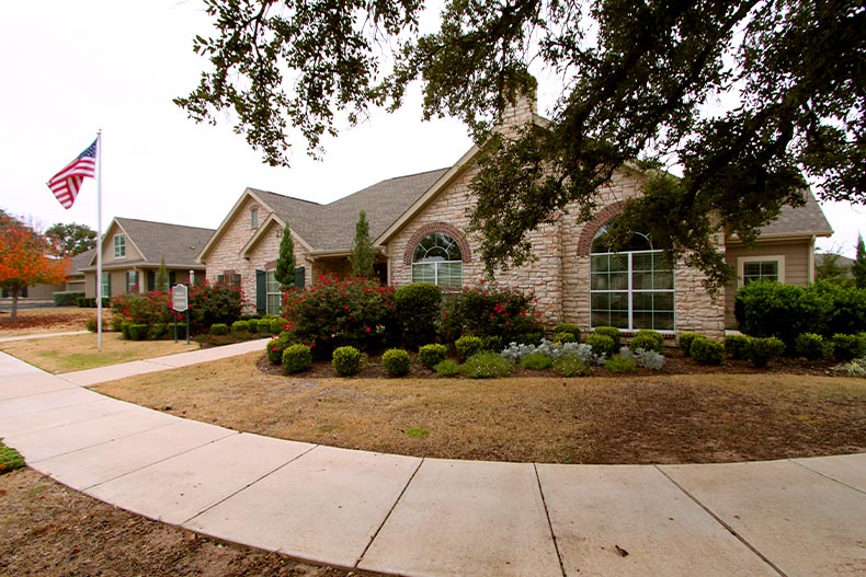 Exterior view of the clubhouse in Oaks at Wildwood surrounded by greenery, located in Georgetown, Texas