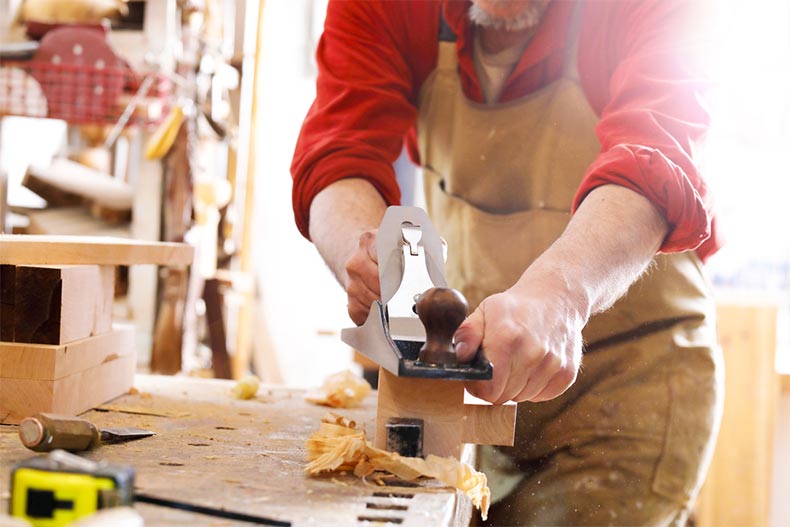 Man sawing wood in woodworking shop