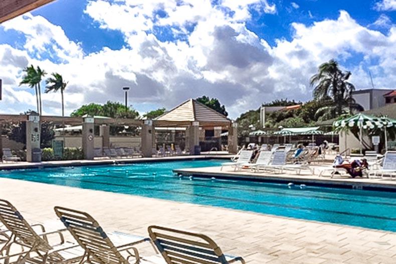 Lounge chairs beside the outdoor lap pool at Wynmoor Village in Coconut Creek, Florida